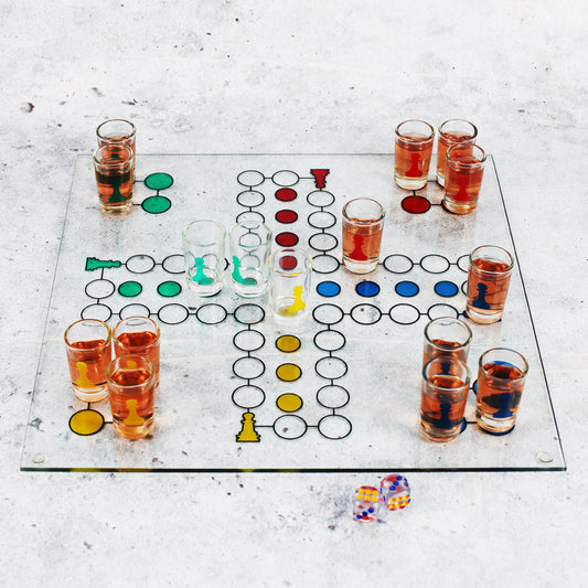 Glas Trinkspiel mit Shots auf einem bedruckten Spielfeld