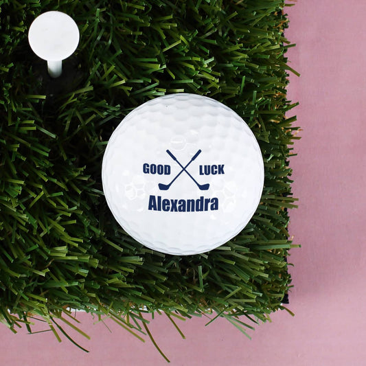 Golfball mit sich zwei kreuzenden Golfschlägern, dem Schiftzug " Good Luck" und Ihrem Wunschnamen bedruckt